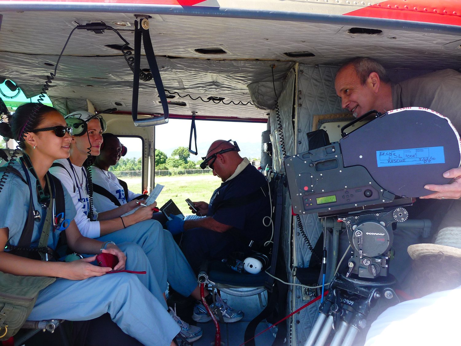Mark Poirier seated beside an IMAX camera inside a helicopter